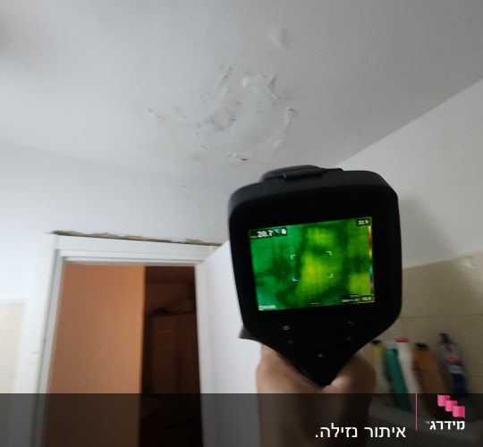 מכשיר תרמי בודק נזילות בתקרה עם כתמים